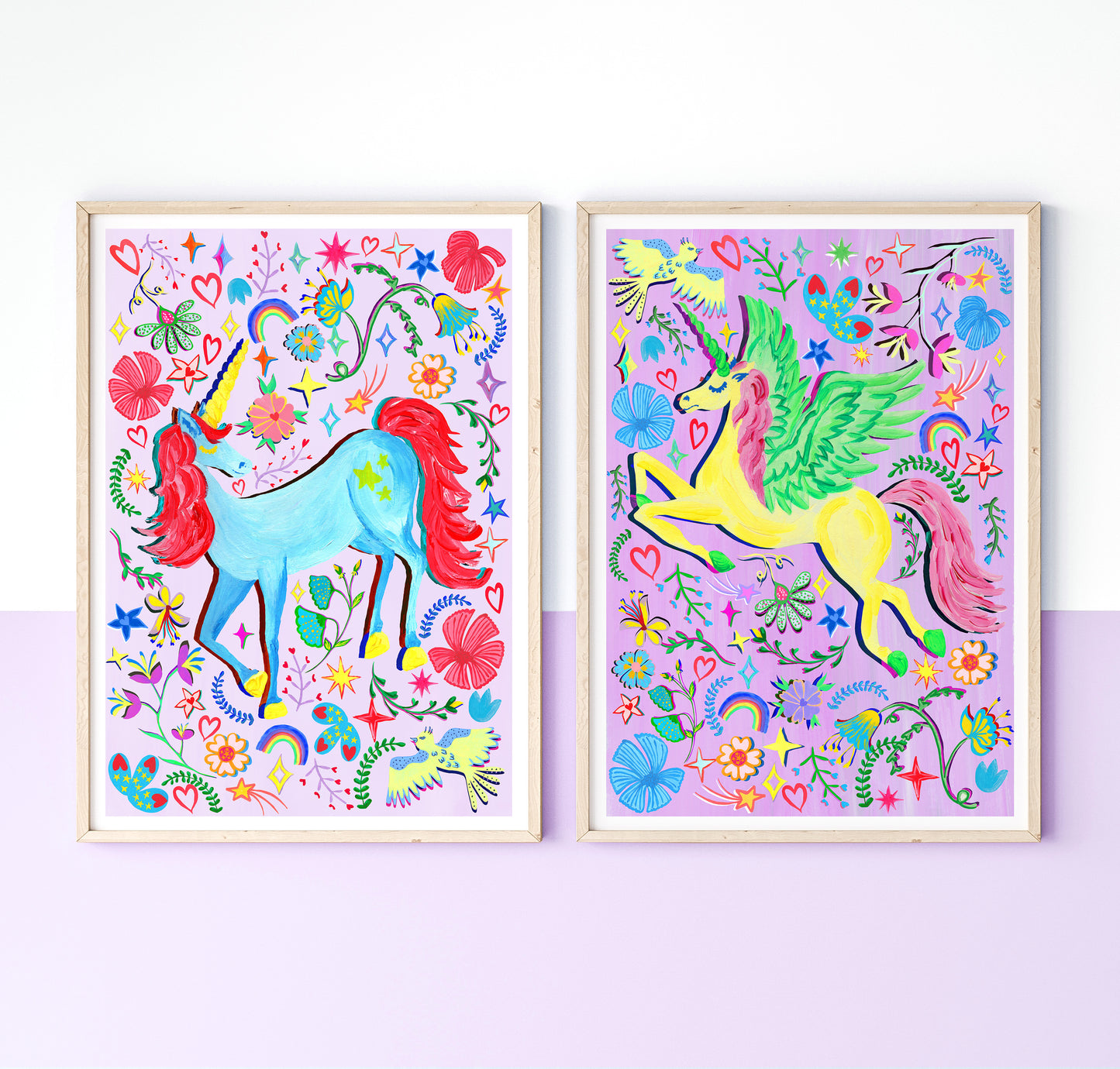 A set of 2 colourful Unicorn prints on lilac and purple background surrounded by colourful flower and rainbow illustrations, placed in light wood frames on a white and liac wall.