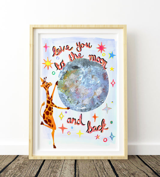 Framed artwork with a giraffe and moon illustration and text 'Love you to the moon and back' on a wooden floor.