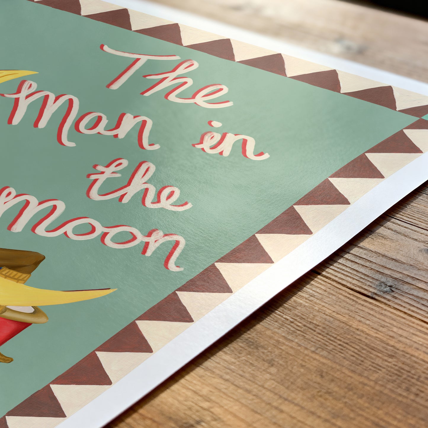 Poster with 'The Man in the Moon' text on a wooden surface