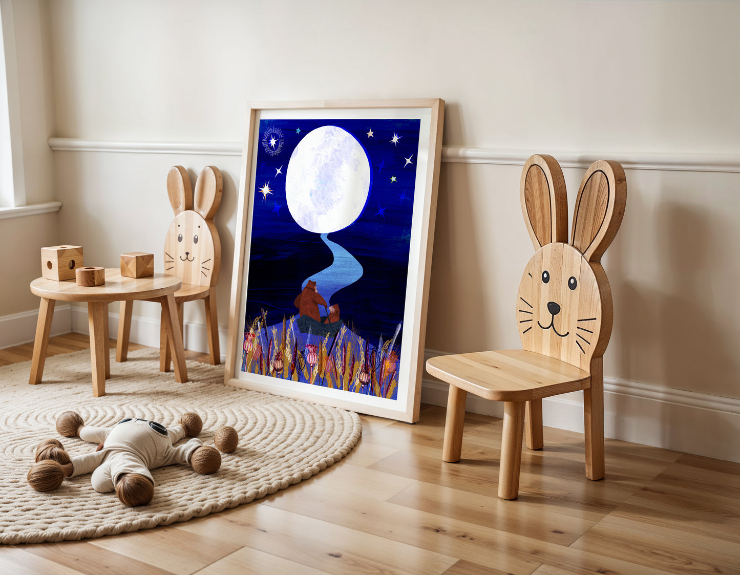 Children's room with wooden chairs shaped like rabbits, a small table, and a framed picture of a moonlit scene.