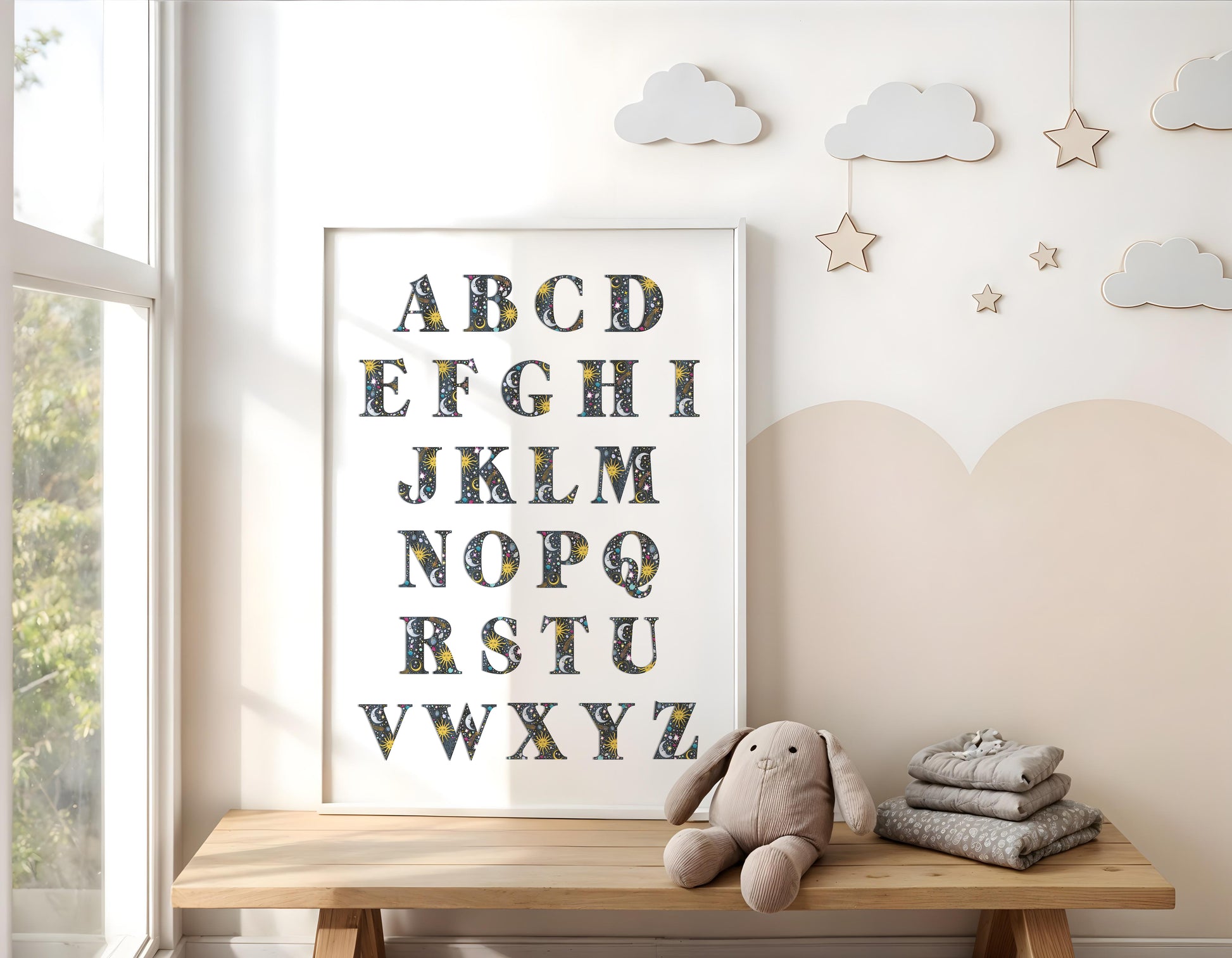 Children's room with a framed alphabet poster, teddy bear, and folded blankets on a wooden bench.