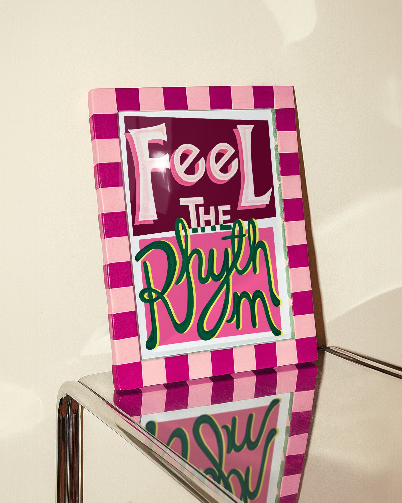 Decorative sign with 'Feel The Rhythm' text on a pink and white checkered background