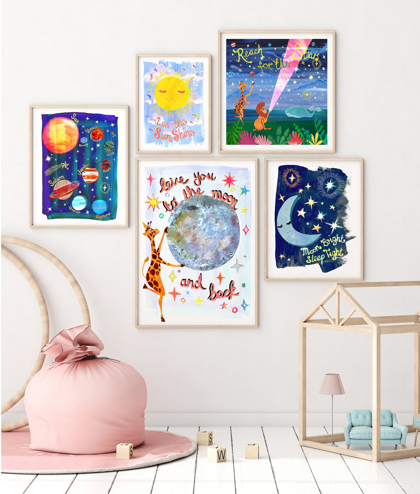 Colorful children's wall art prints on a white wall with a pink bean bag chair and wooden toys below.