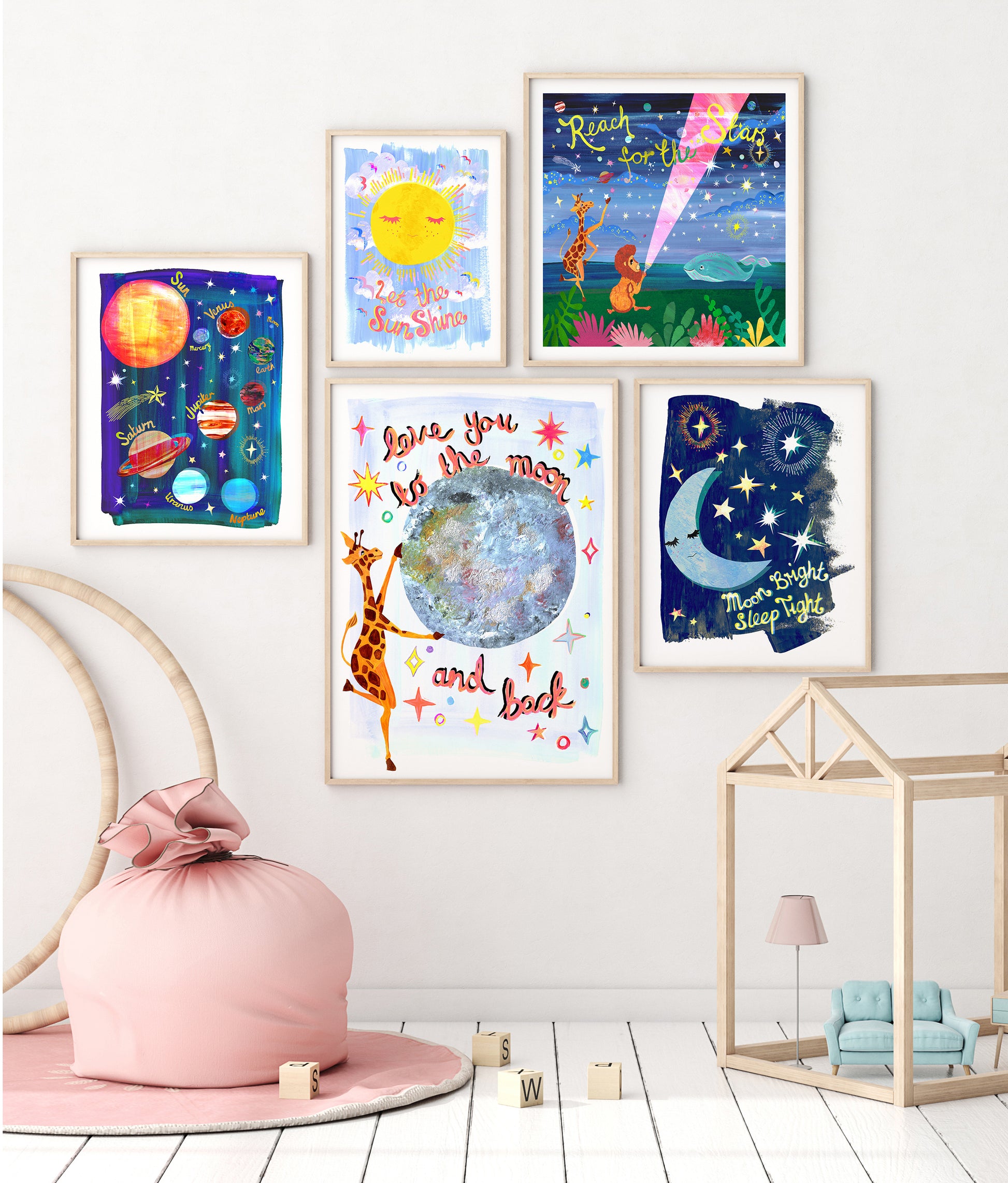 Colorful children's wall art prints on a white wall with a pink bean bag chair and wooden toys below.