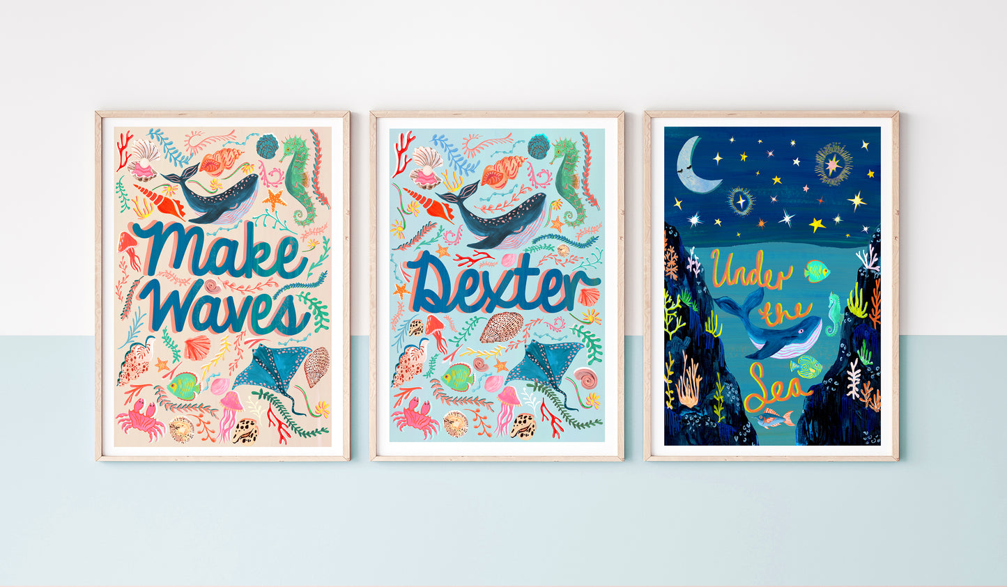 Three framed artworks with ocean-themed designs on a light blue wall.