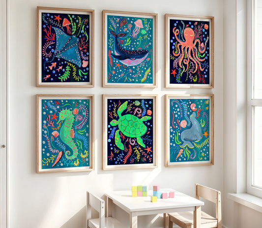 Colorful framed artworks of sea creatures on a wall above a child's table.