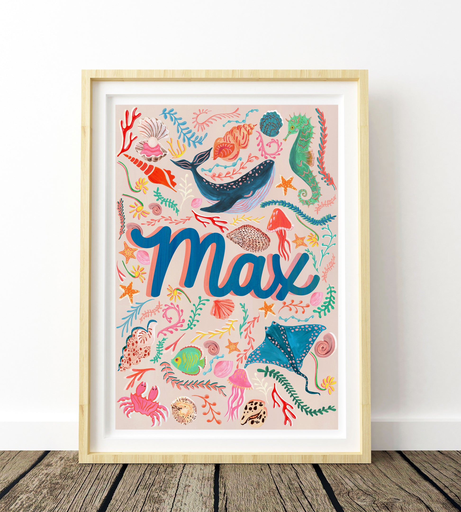Framed artwork with colorful sea-themed design and the name 'Max' on a white wall.