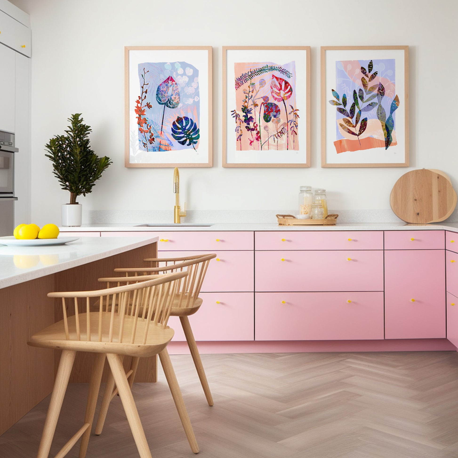 Modern kitchen with pink cabinets, wooden chairs, and colorful wall art.