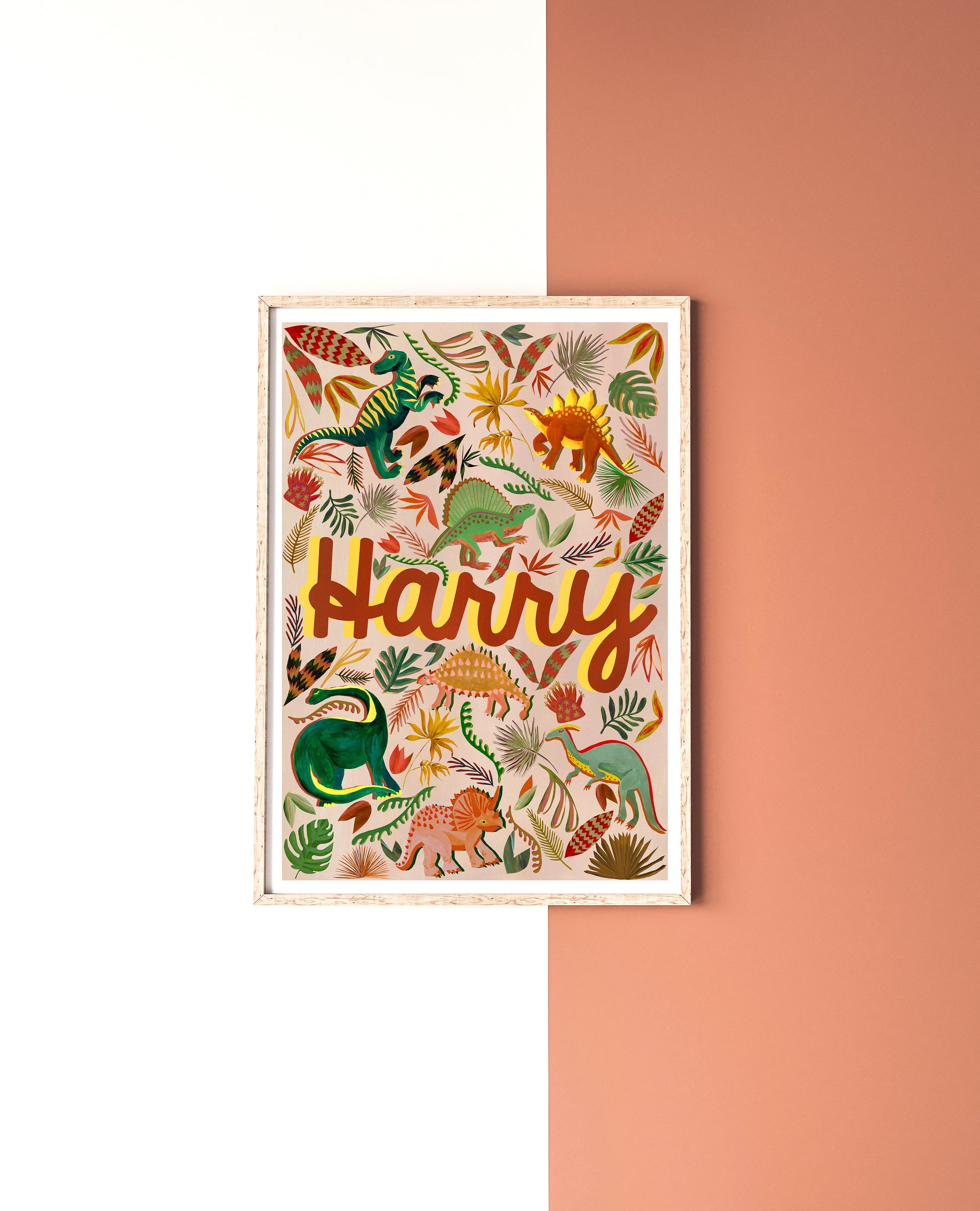 Framed artwork with colorful dinosaur illustrations and the name 'Harry' on a white and pink background.