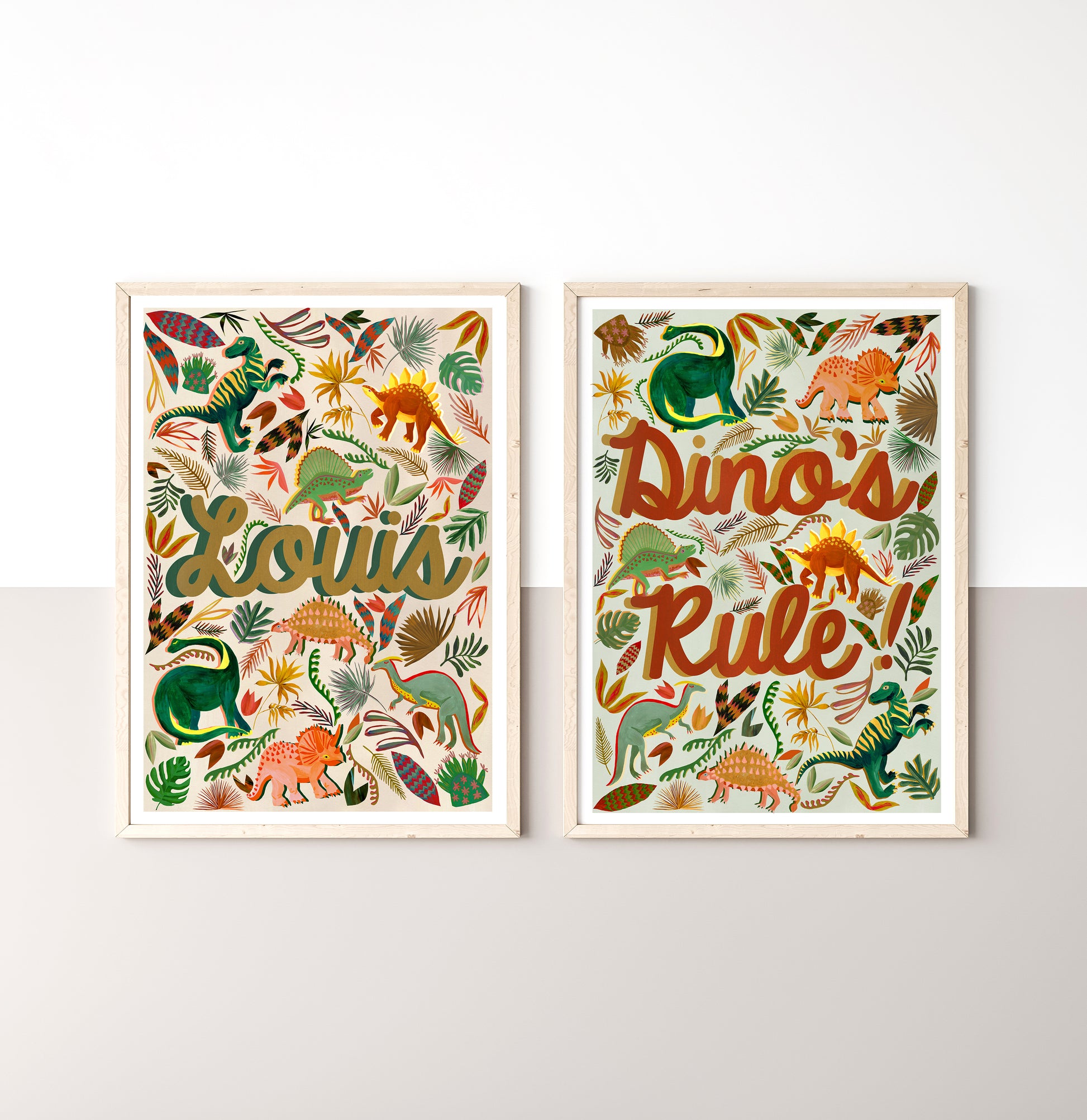 Two framed dinosaur-themed prints on a white wall.