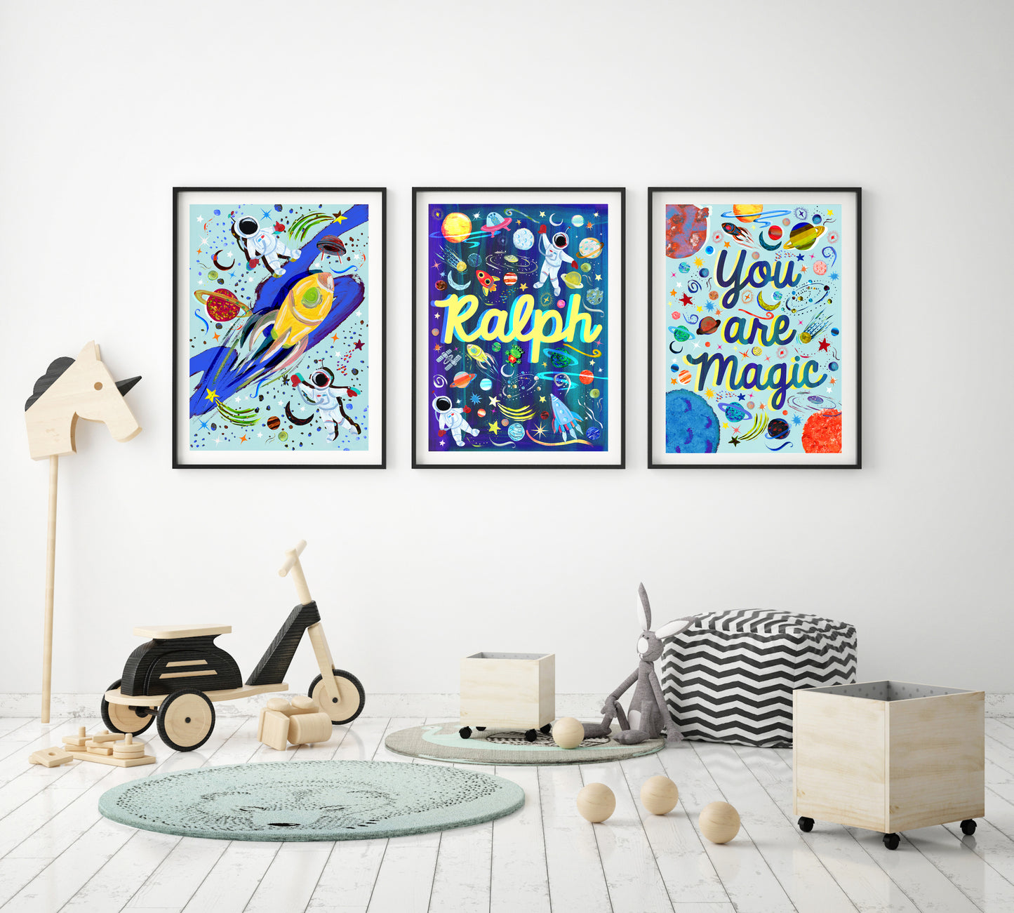 Three colorful children's posters on a wall in a room with toys and furniture.