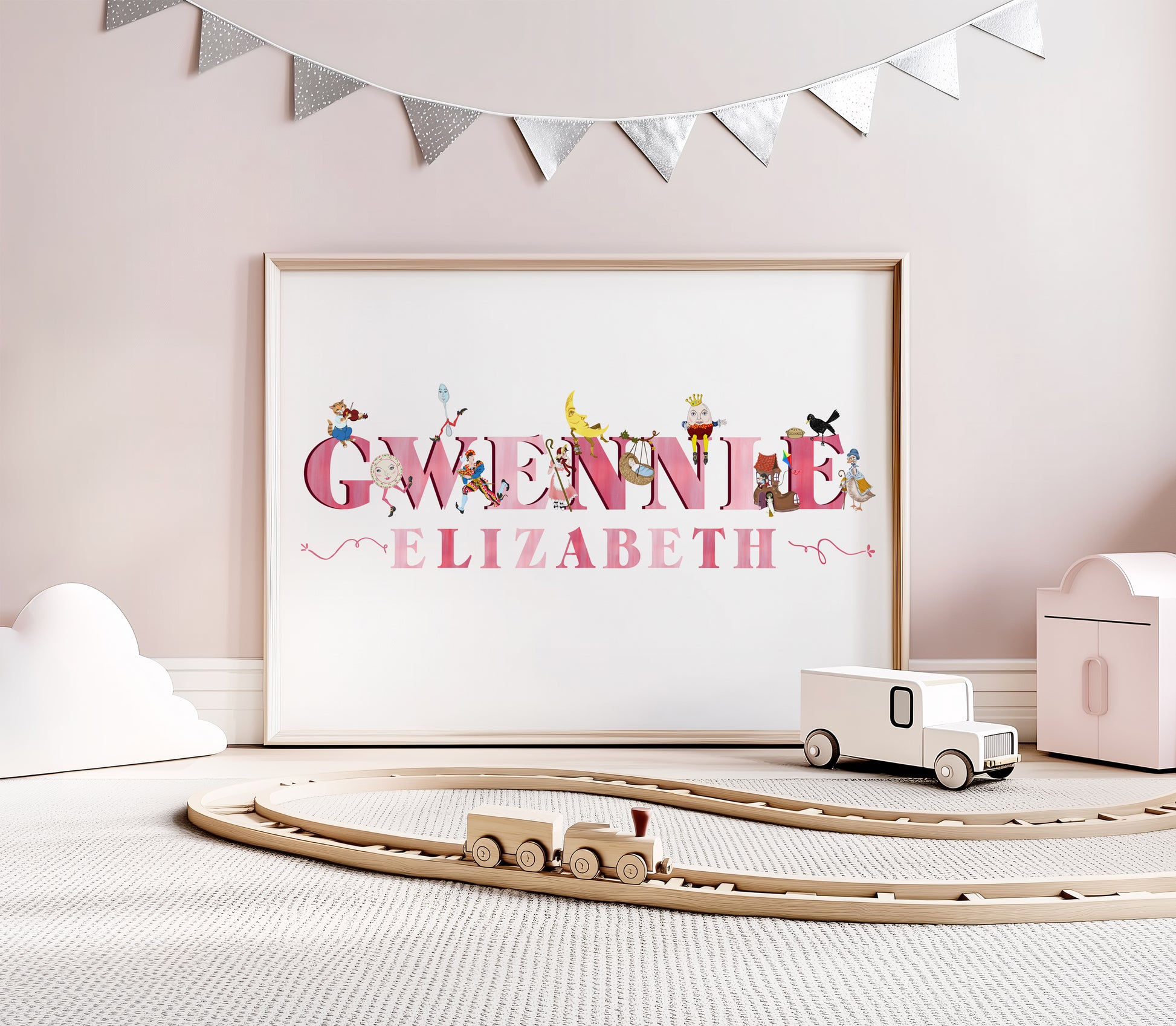 Personalized pink lettered name art on a wall with a wooden toy train set below