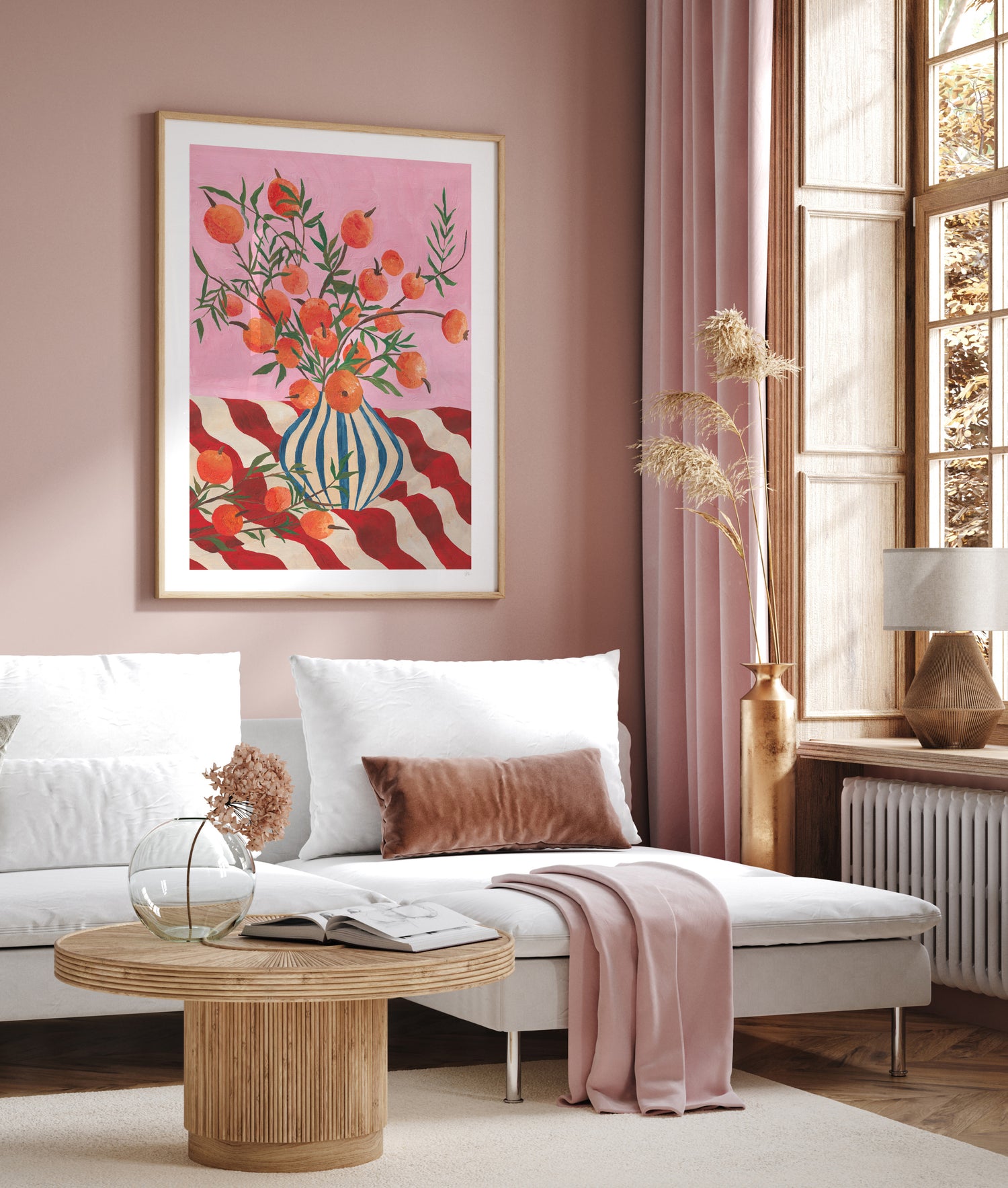 Living room with a vase of clementines painting on the wall, a white sofa, and a wooden coffee table.