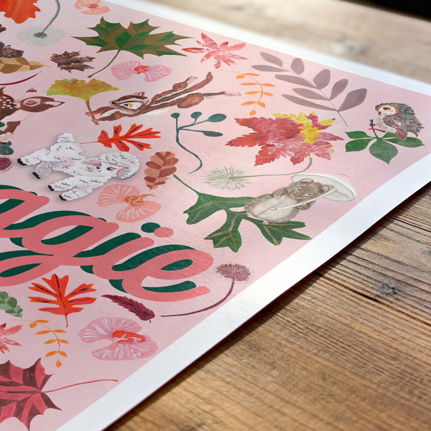 Colorful floral and animal patterned paper with 'Aggie' text on a wooden surface