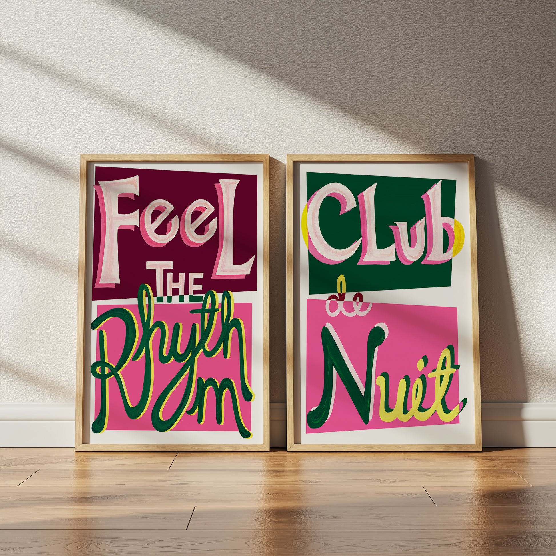 Two framed posters with colorful text on a wooden floor.
