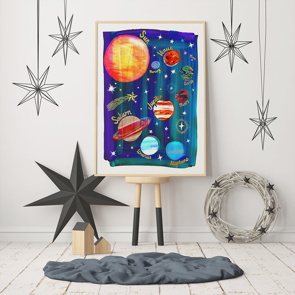 Colorful space-themed wall art with planets on a white wall with decorative stars.