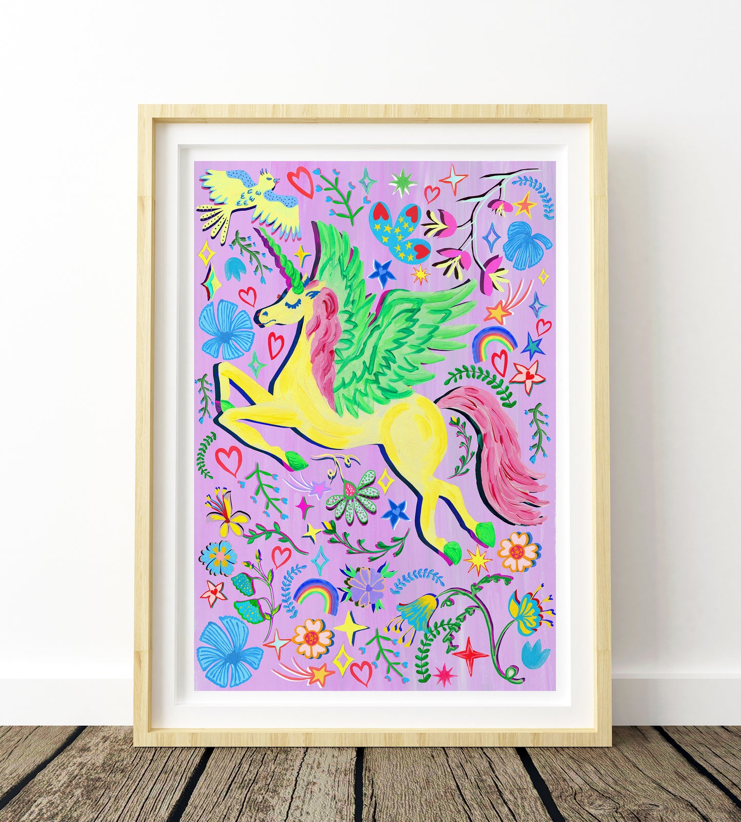 A colouful yellow unicorn painting place against a purple bacground and surrounded by flower and rainbow illustrations in a light wood frame.