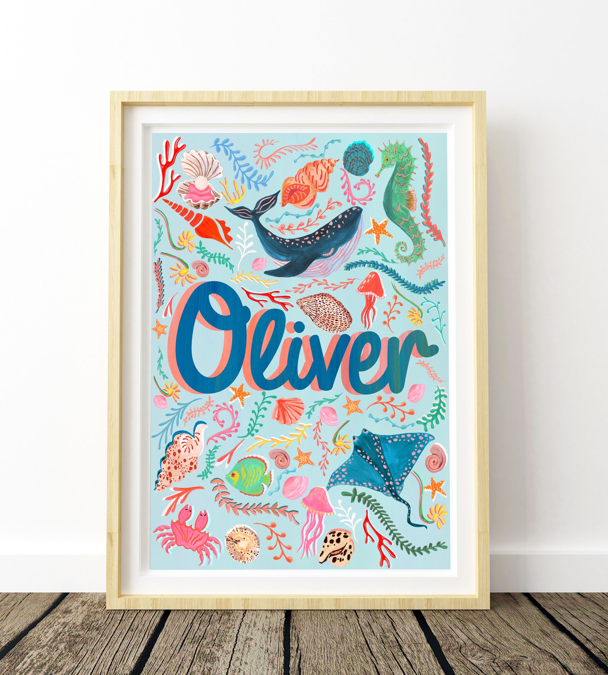 Framed children's wall art with colorful sea-themed illustrations and the name 'Oliver'.