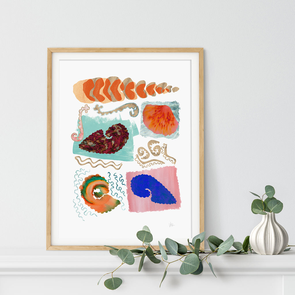 Framed abstract artwork with colorful shapes on a white wall.