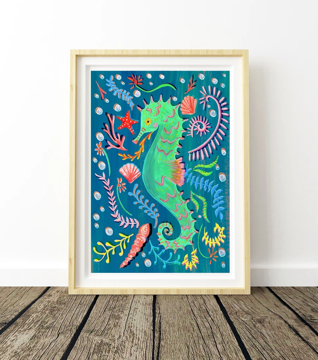 Framed artwork of a colorful seahorse and sea life on a blue background.