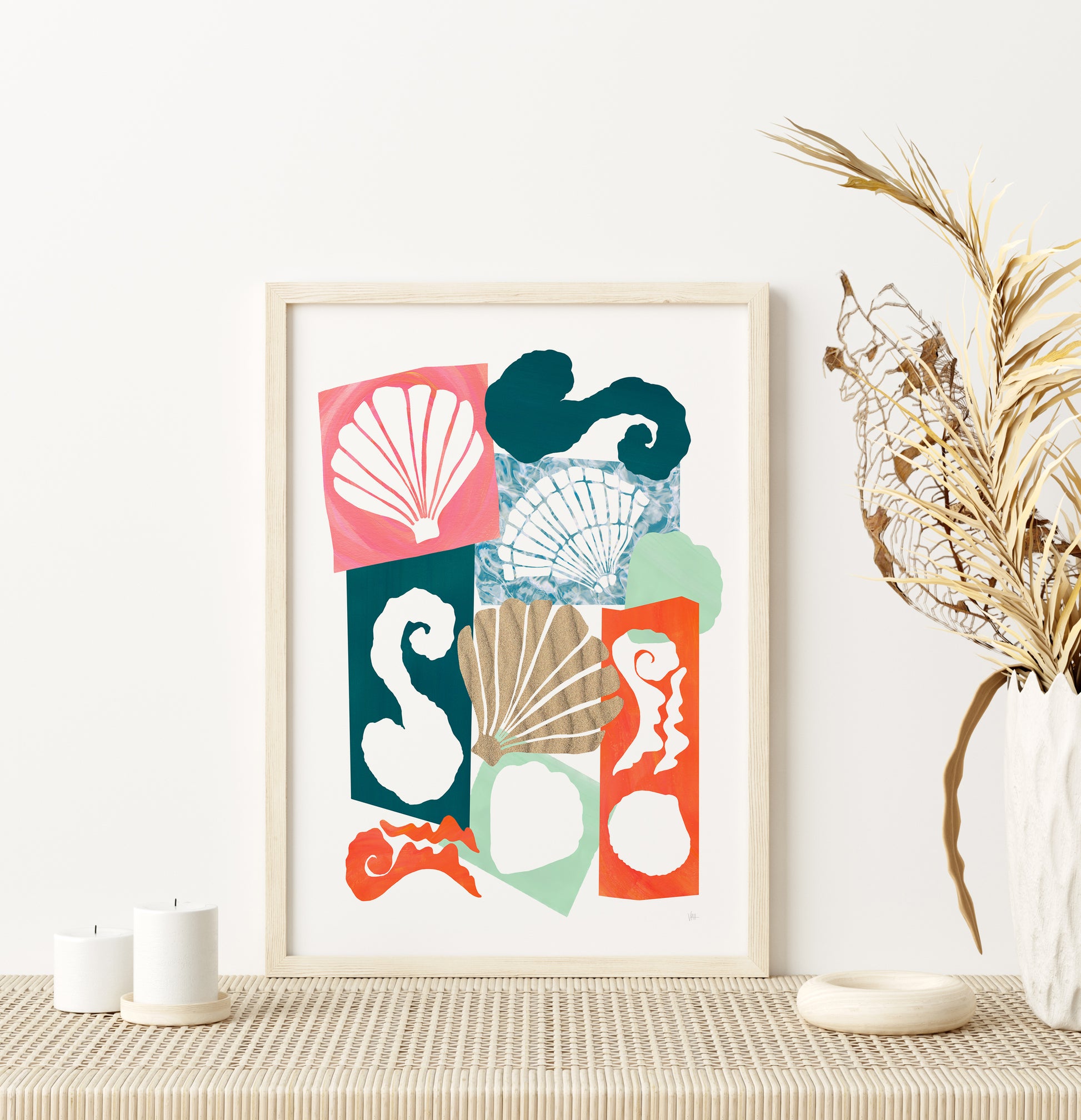 Framed abstract art print with colorful shapes on a wall above a table.