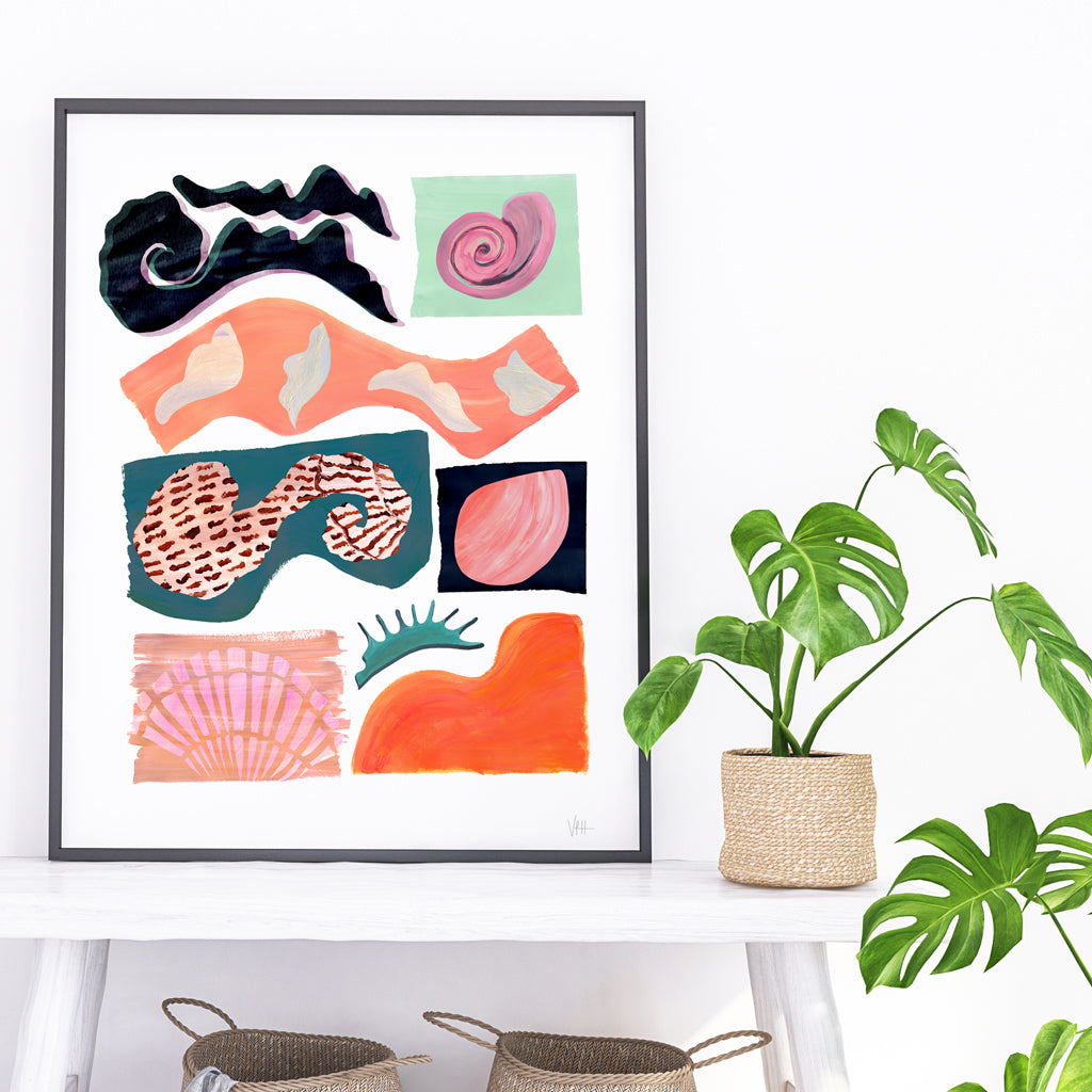 Framed abstract art piece on a white wall with plants below