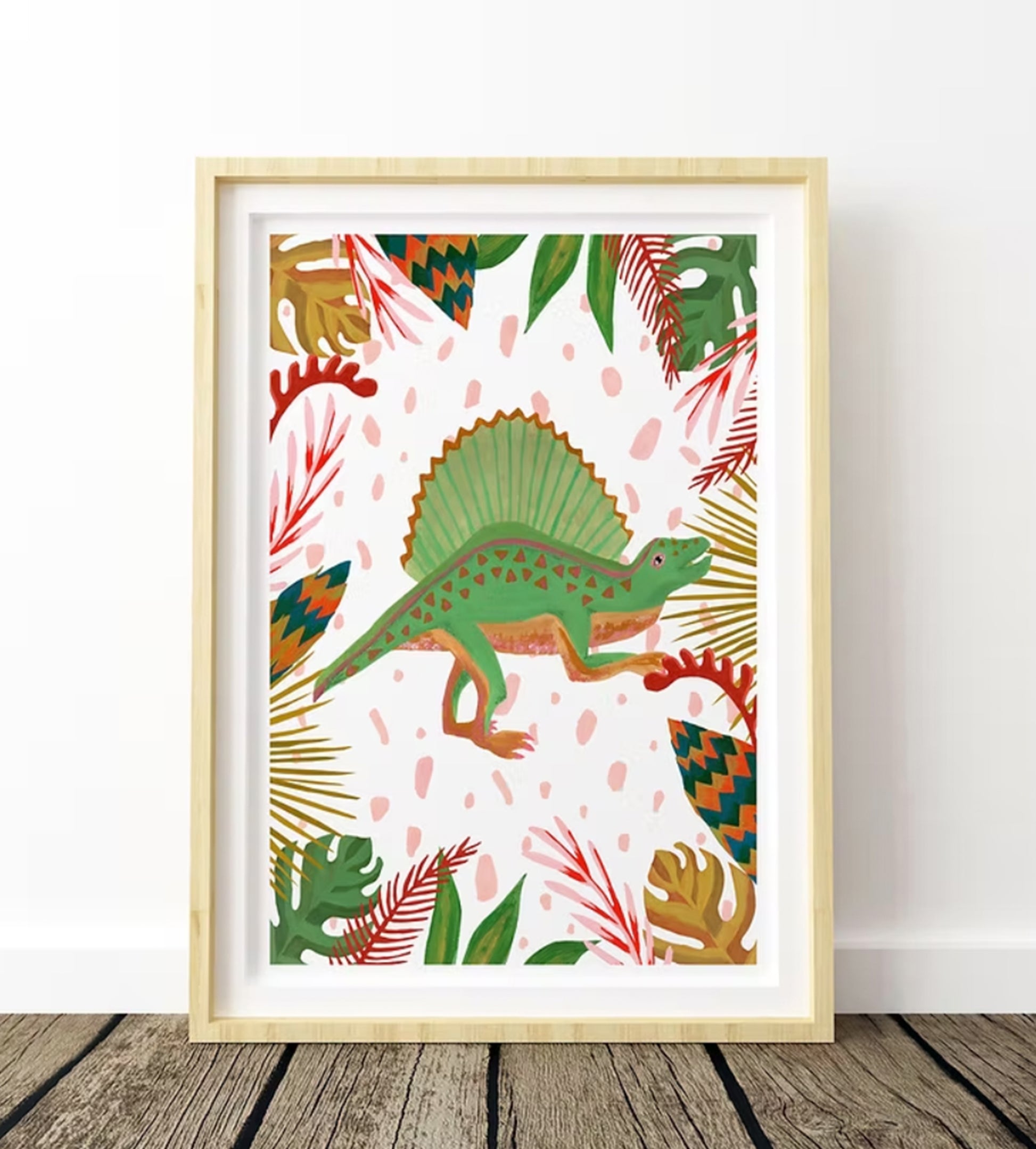 Framed artwork with a green dinosaur and colorful leaves on a white background