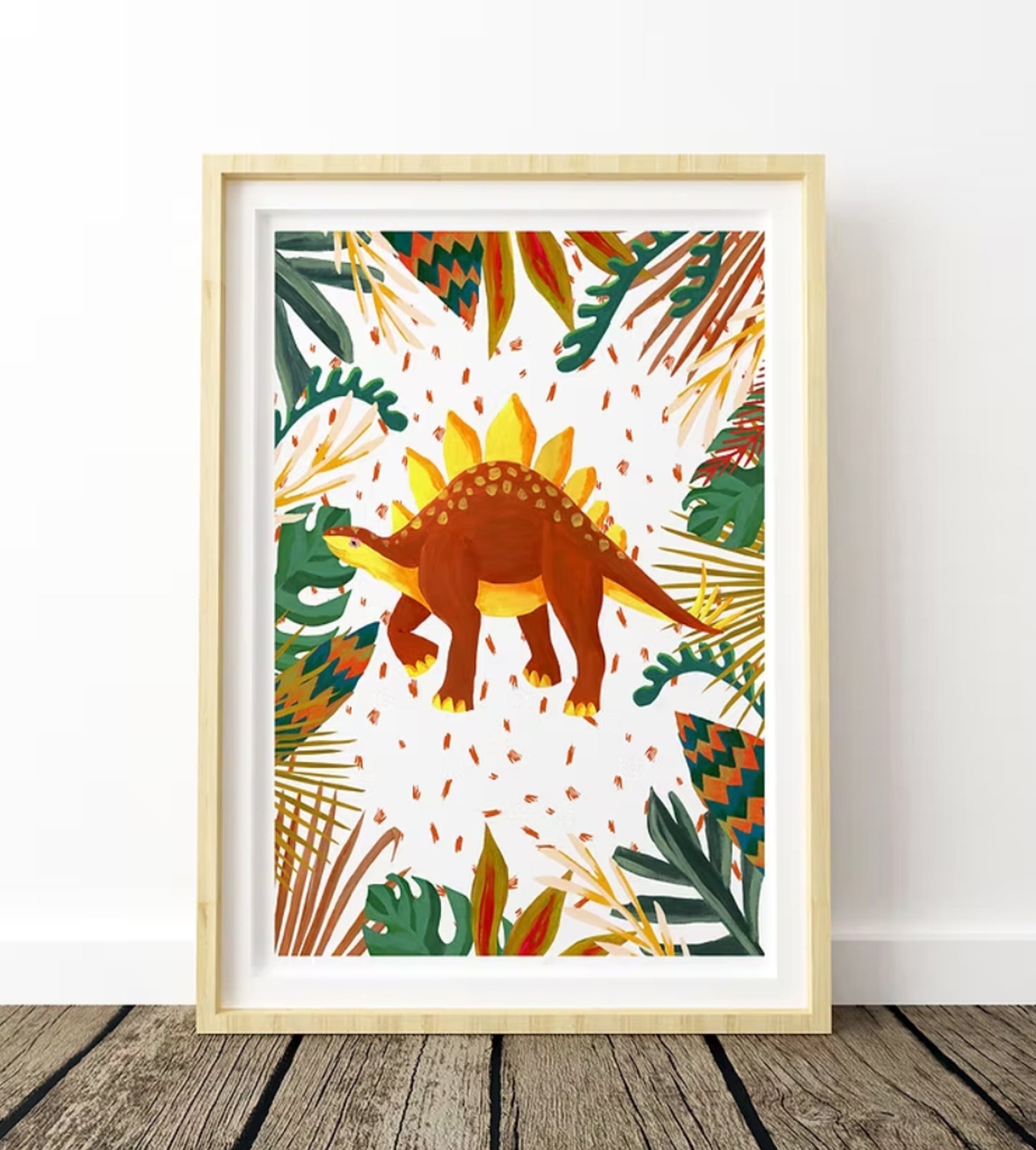 Framed artwork with a dinosaur and tropical leaves on a white background