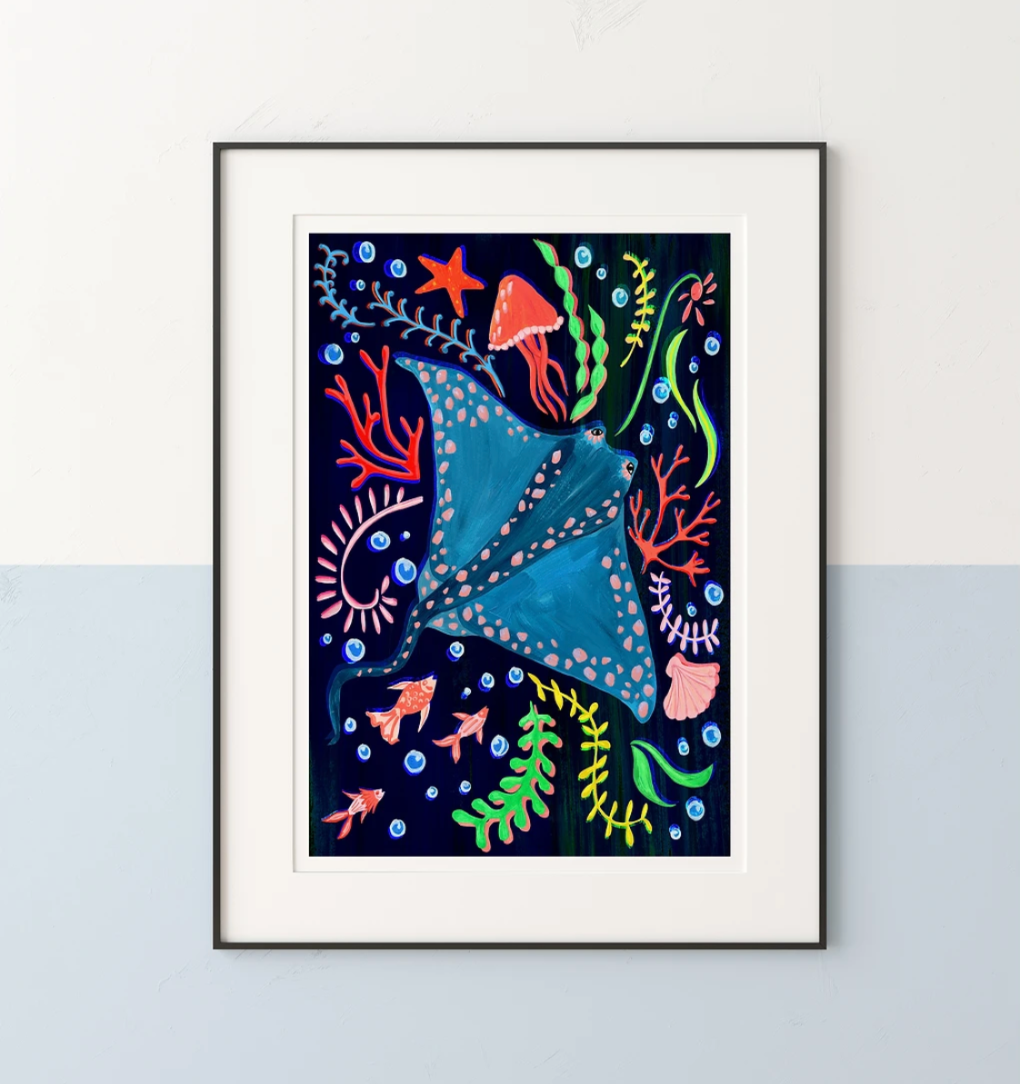 Framed artwork of a colorful stingray and underwater plants on a white wall.