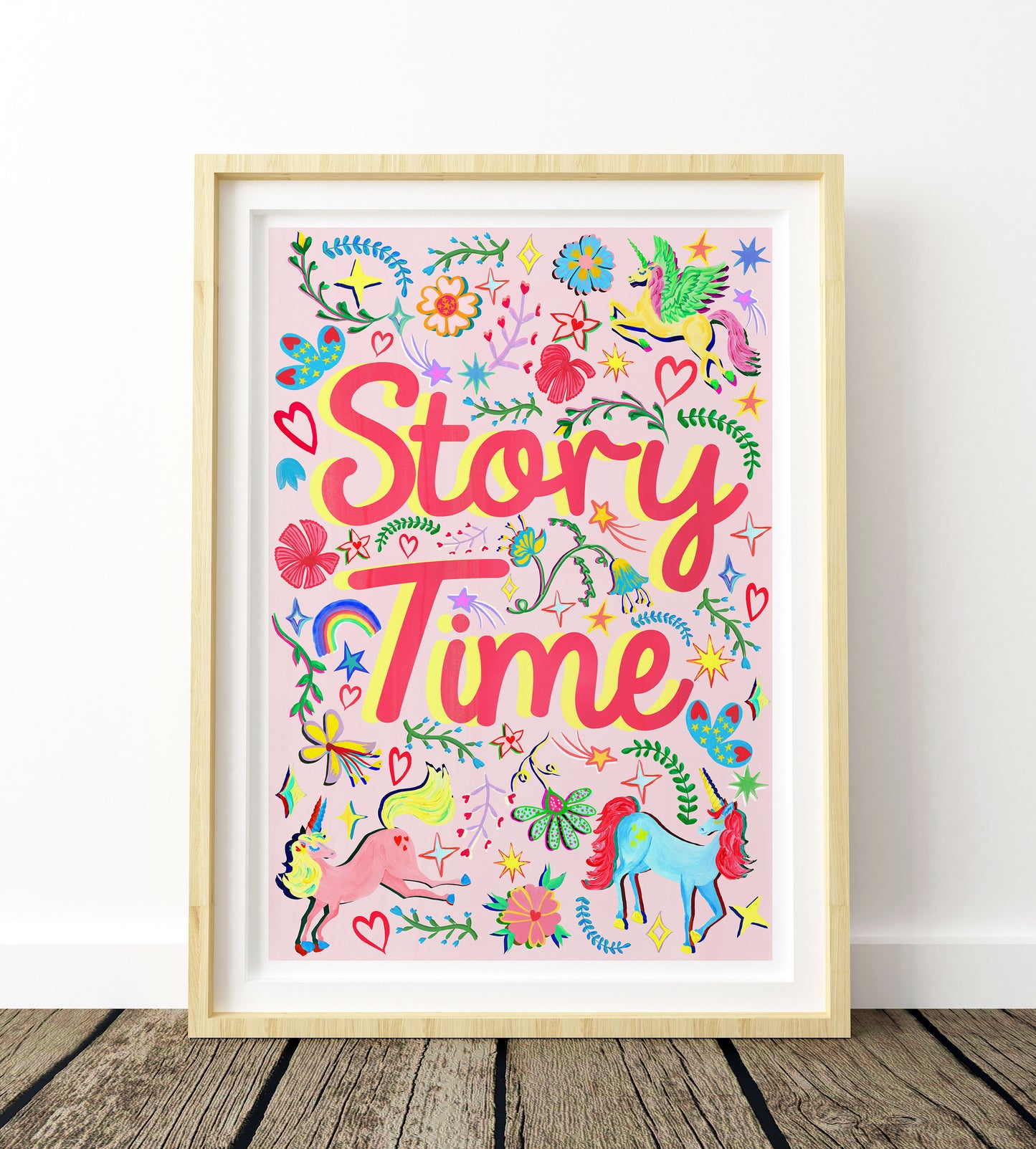 Colorful 'Story Time' poster with unicorns and flowers in a wooden frame on a white wall.