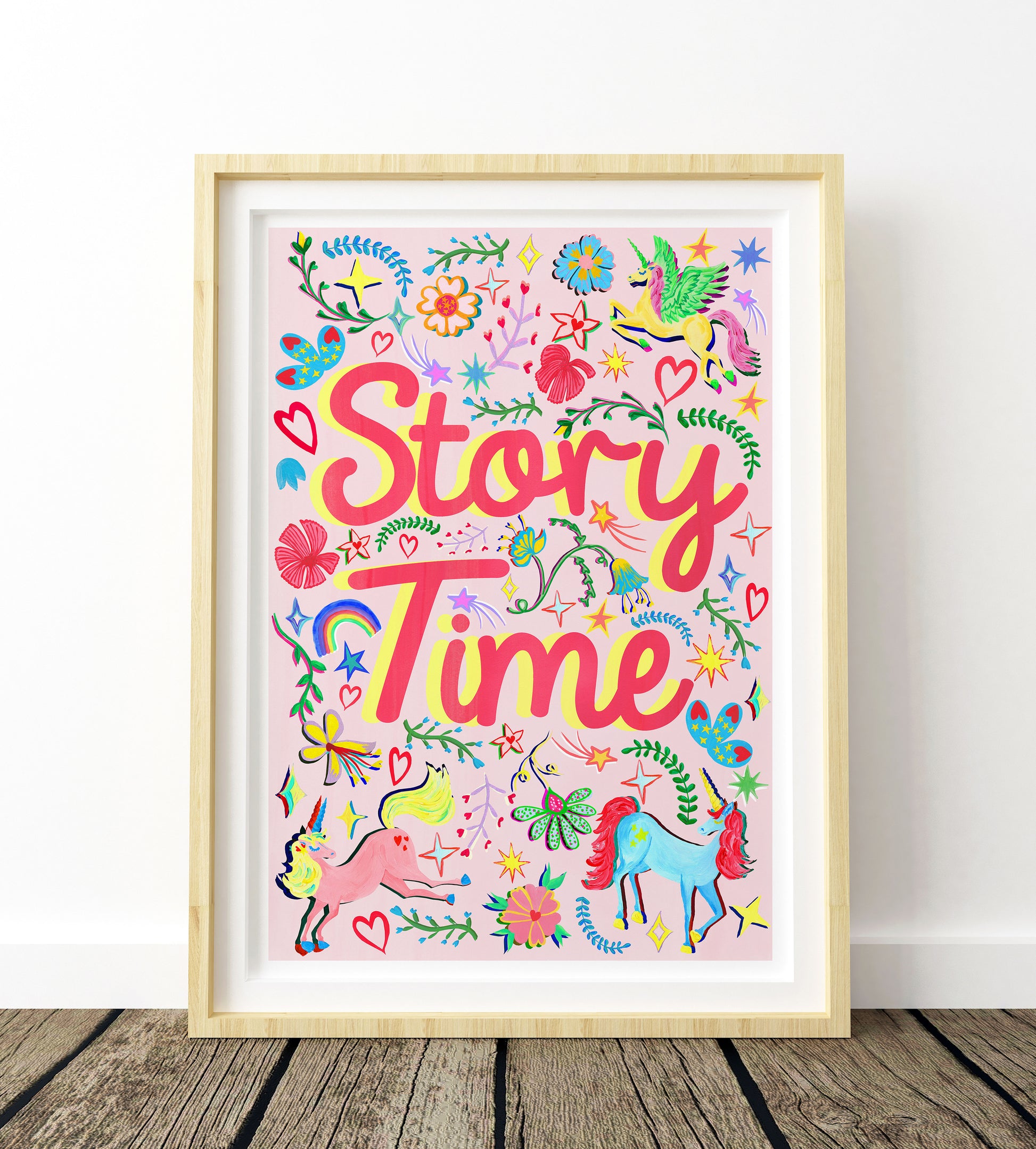 Colorful 'Story Time' poster with unicorns and flowers in a wooden frame on a white wall.