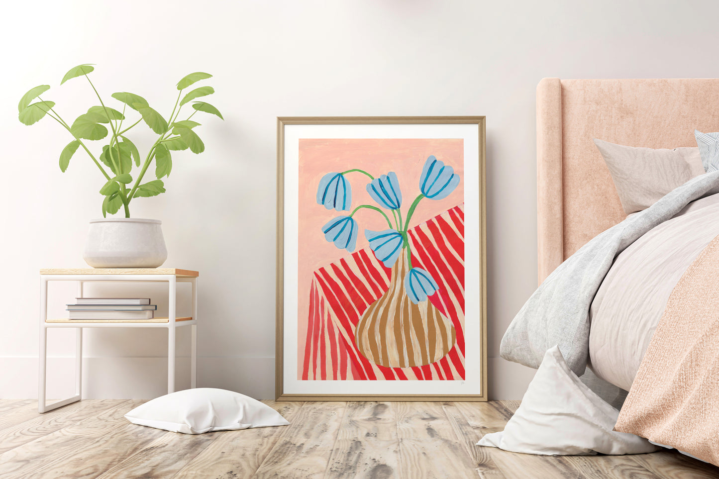 Framed abstract art print of a vase with blue flowers on a wall in a bedroom.