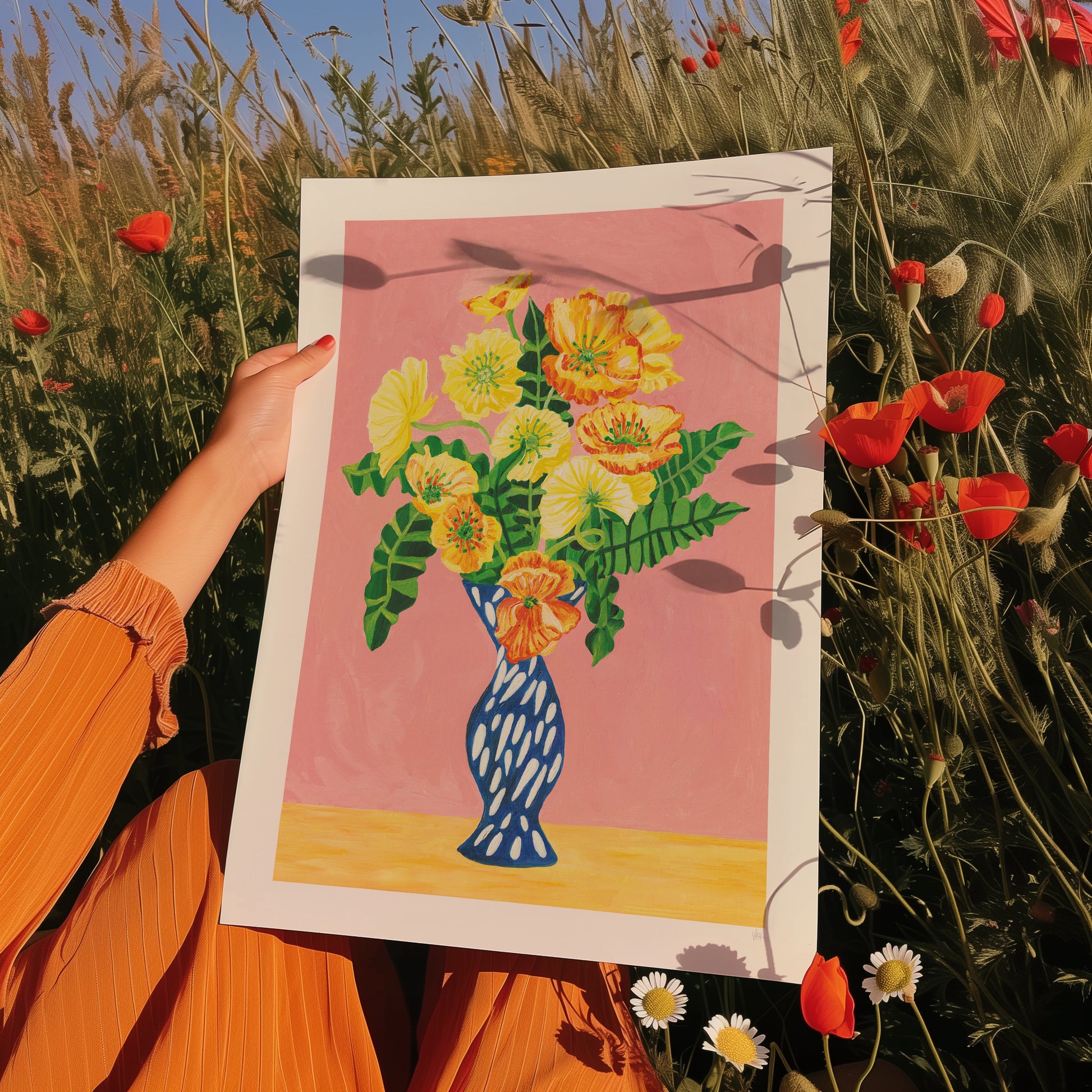 Person holding a floral painting in a field of flowers