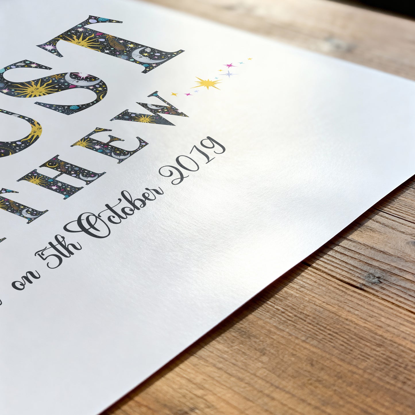 Decorative with sun, moon and star illustrations name print on a wooden surface