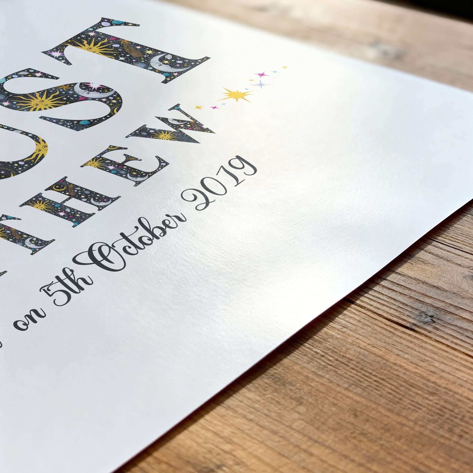Decorative with sun, moon and star illustrations name print on a wooden surface