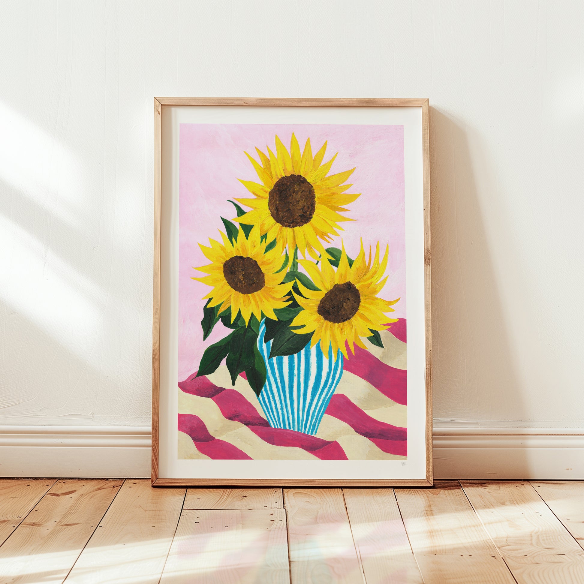 Framed artwork of sunflowers in a vase on a striped background