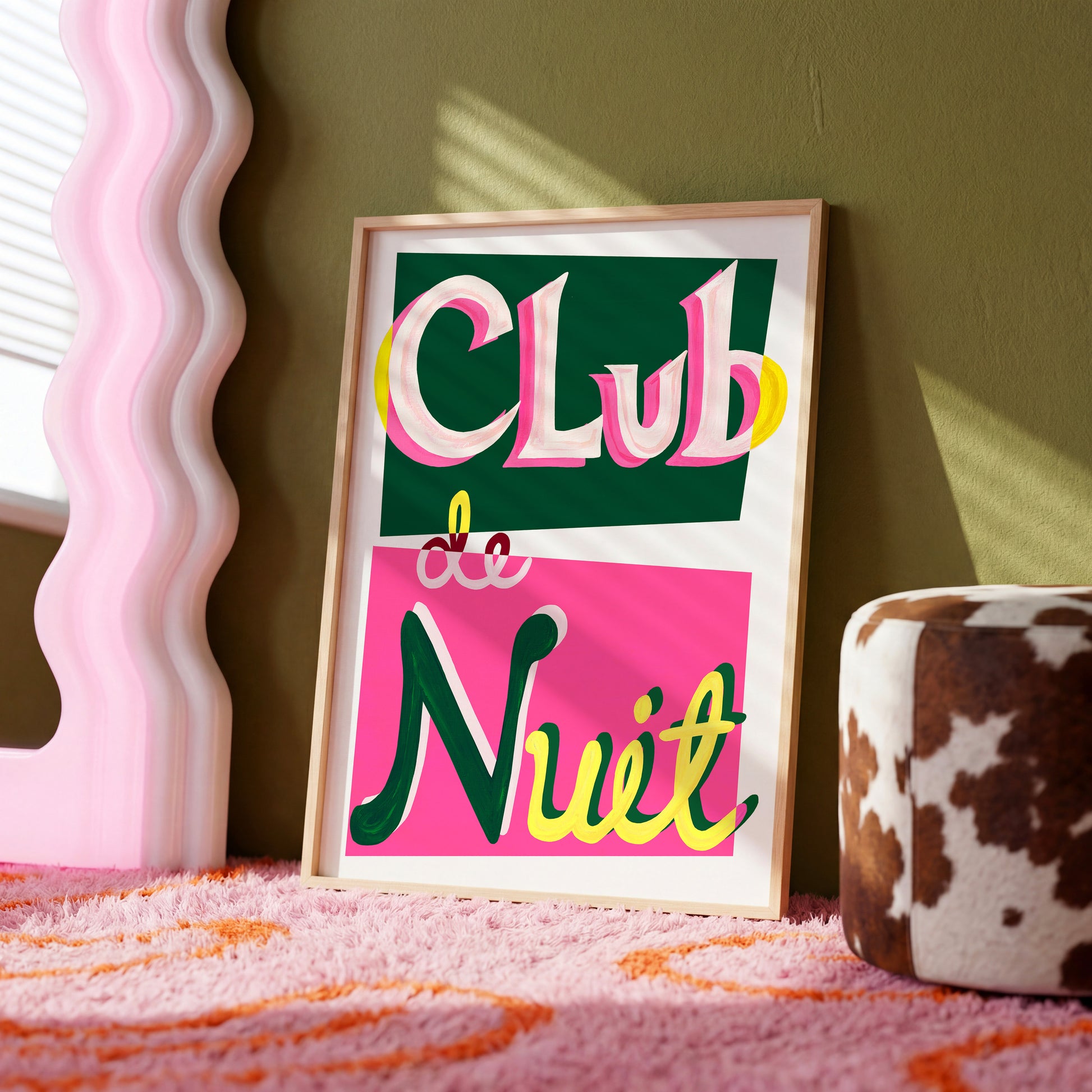Framed artwork with 'Club Nuit' text on a pink surface with a green wall background
