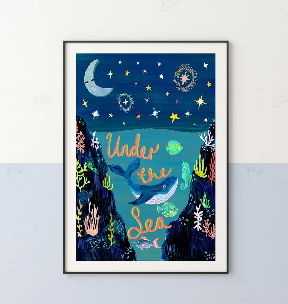 Framed artwork of an underwater scene with a whale, fish, and stars under a moonlit sky.