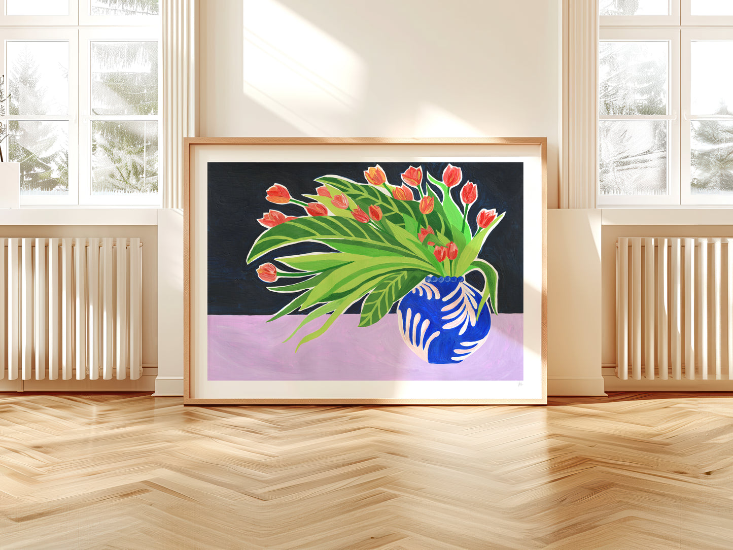 Framed artwork of a blue pitcher with red flowers on a purple background, displayed in a room with wooden floor and windows.