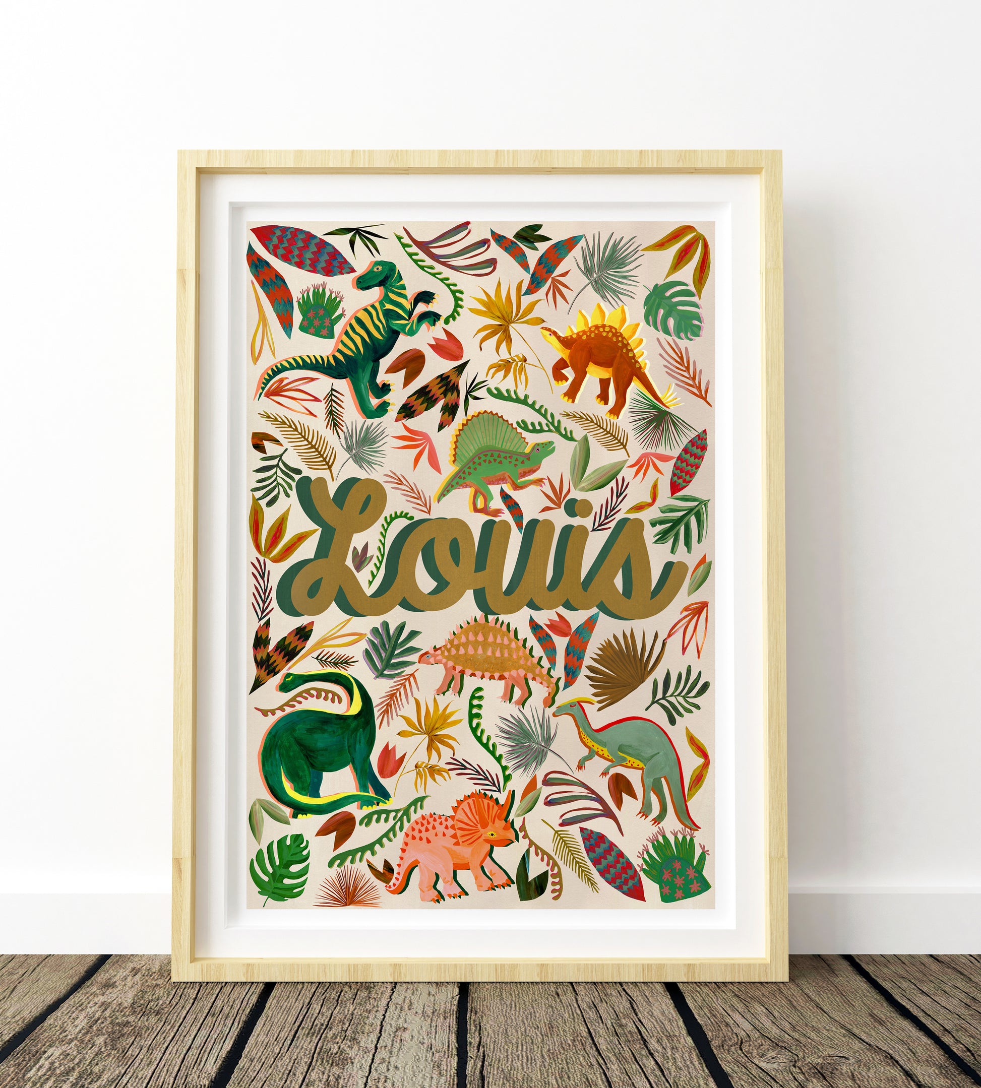 Framed artwork with colorful dinosaur illustrations and the name 'Louis' on a white background.