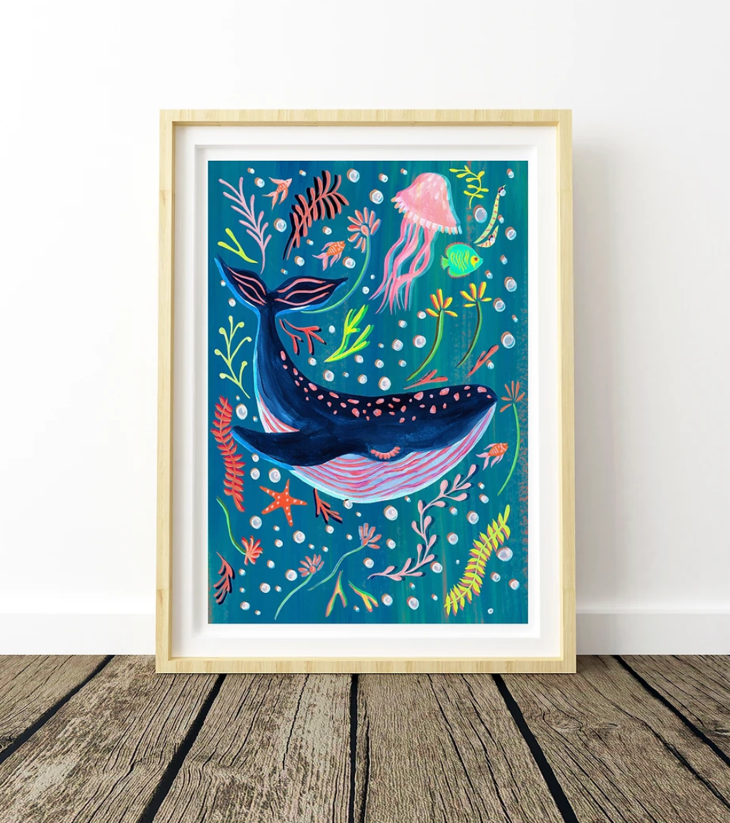 Framed artwork of a whale and underwater creatures on a blue background