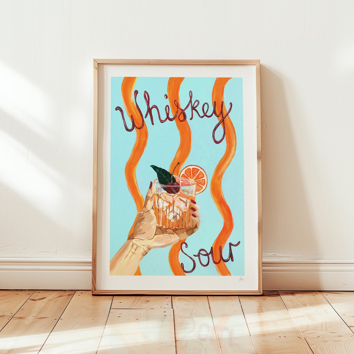 Framed artwork with a hand holding a cocktail and 'Whiskey Sour' text on a light blue background.