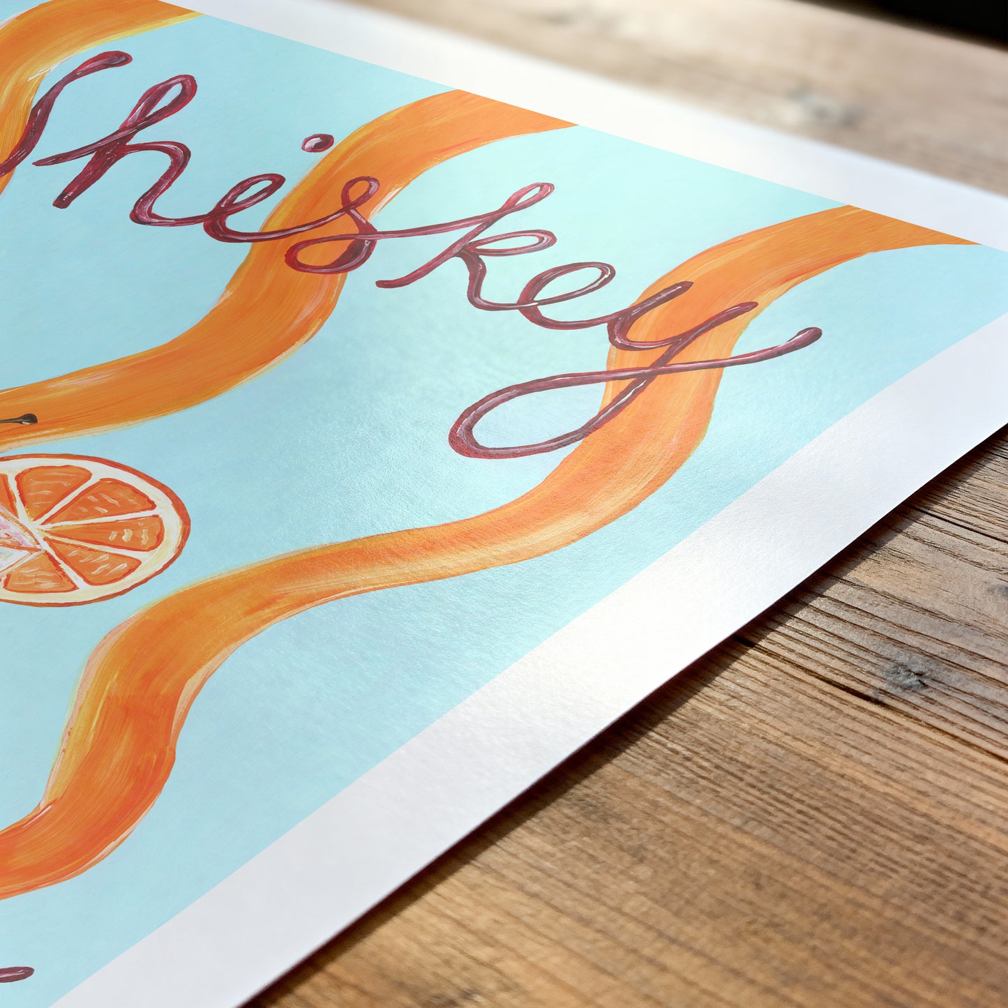 Poster with 'This is Whiskey' text and orange design on a wooden surface
