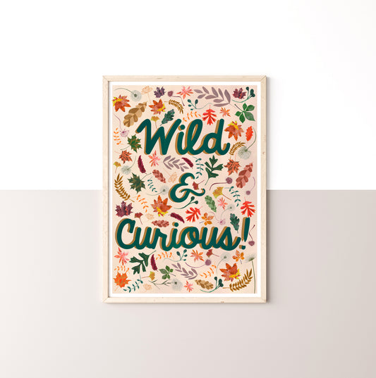 Framed artwork with 'Wild & Curious!' text and leaf designs on a neutralbackground