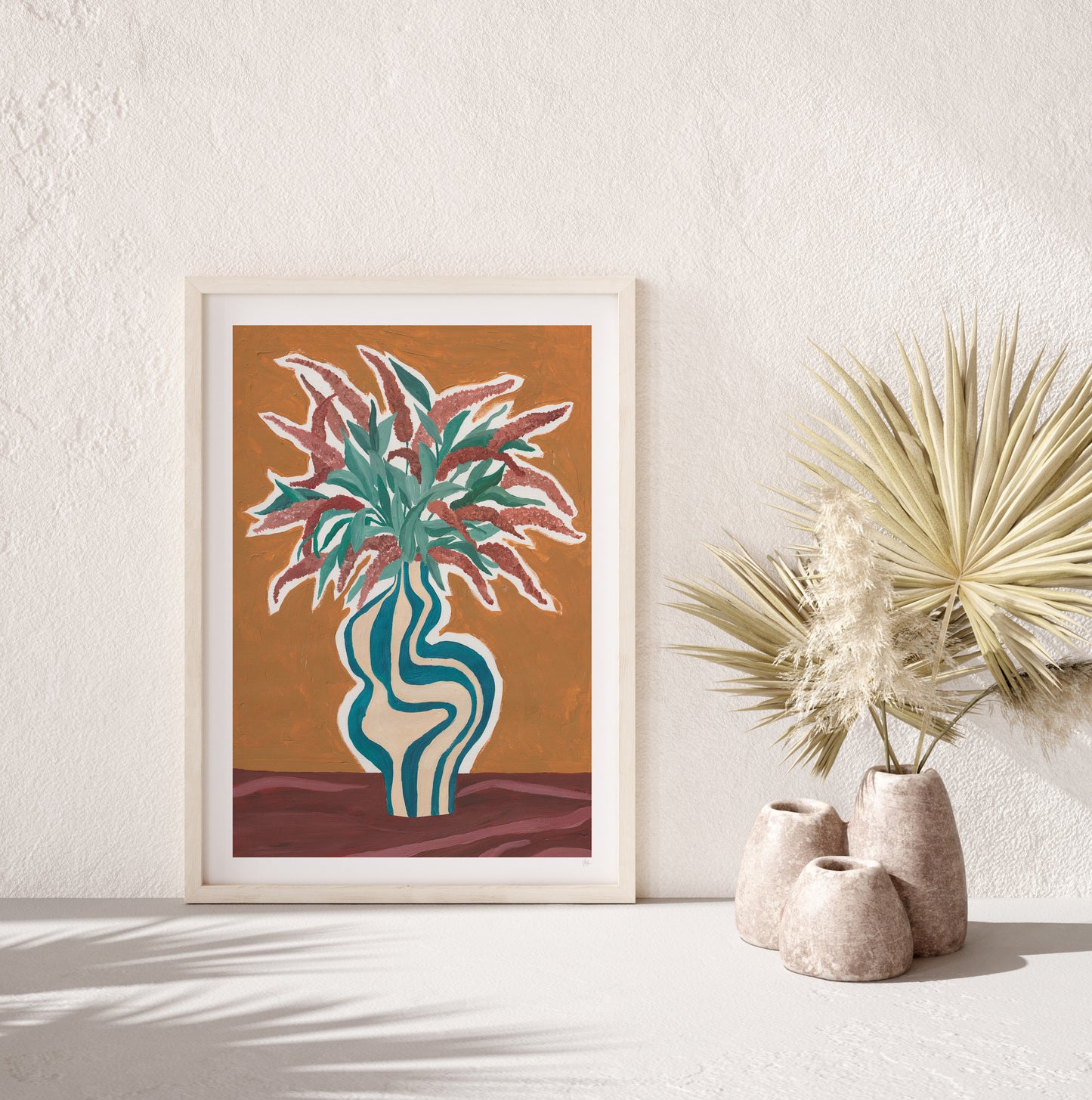 Framed artwork of a plant in a vase on a white wall with decorative vases below.