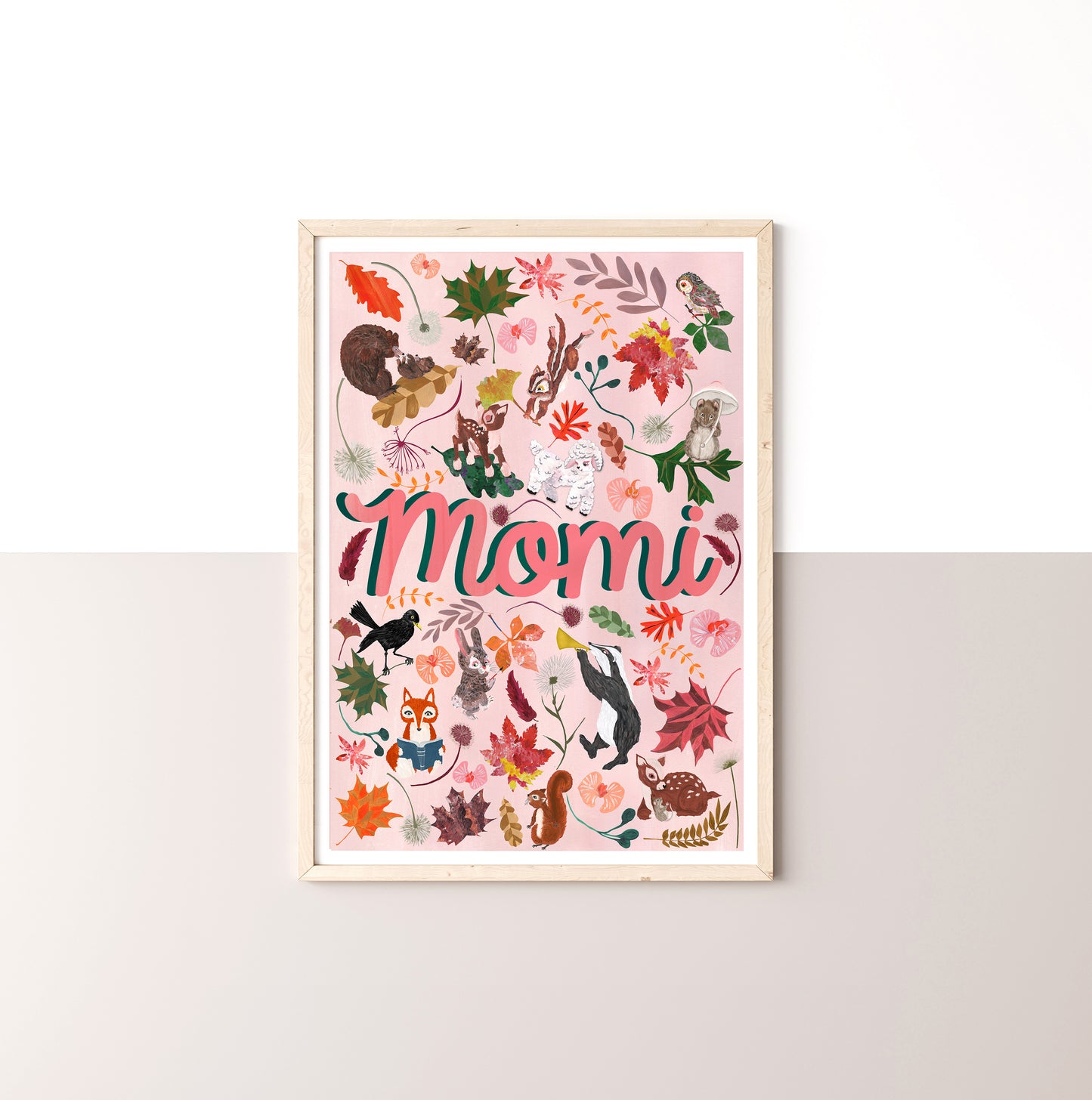 Framed artwork with 'Momi' text and colorful illustrations on a white wall.