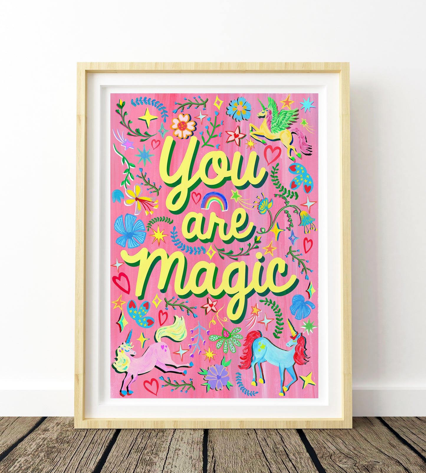 Framed artwork with 'You are magic' text on a pink background with unicorns and flowers.