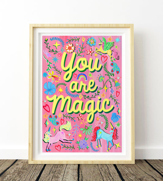Framed artwork with 'You are magic' text on a pink background with unicorns and flowers.