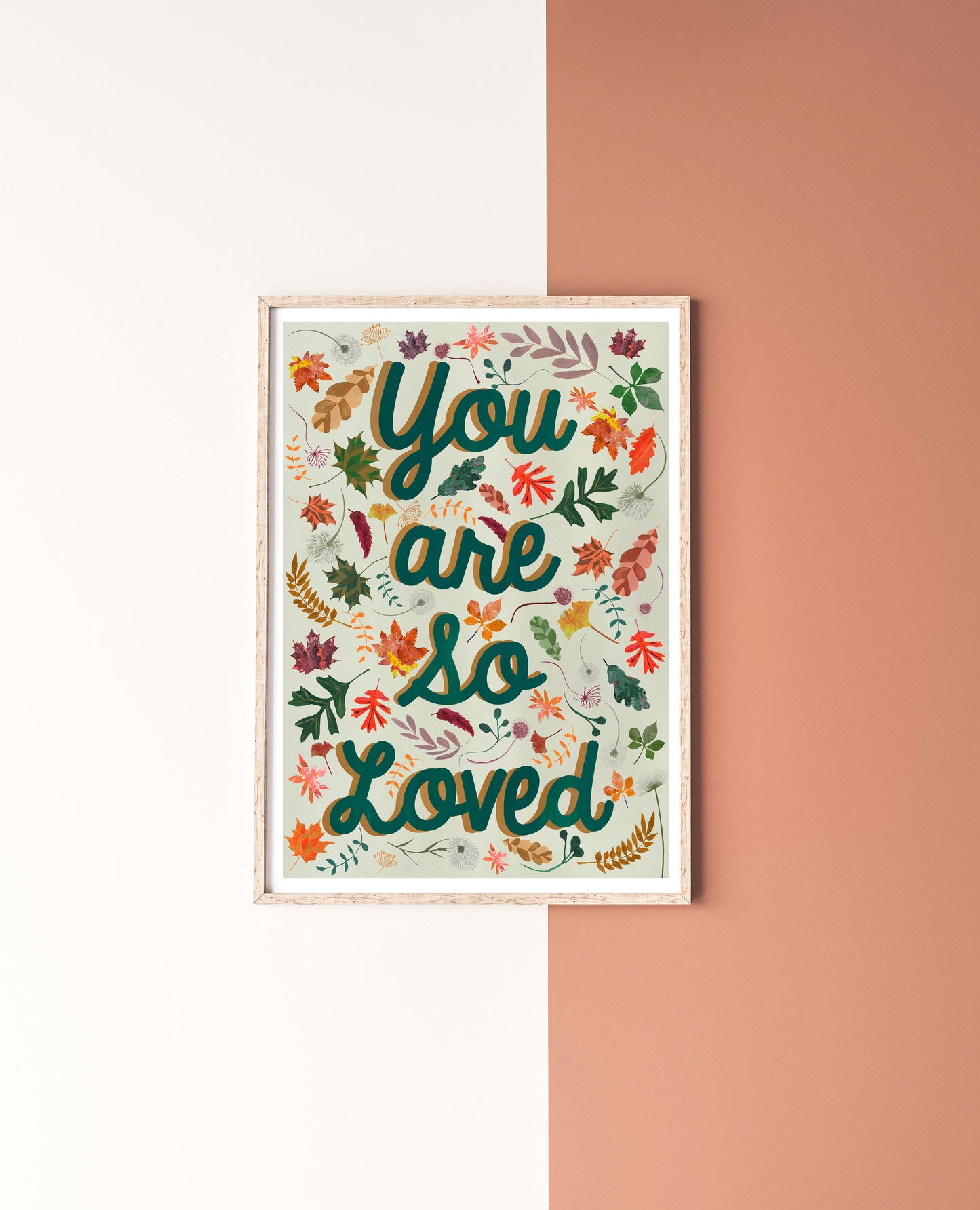Framed artwork with 'You are so loved' text on a two-tone wall.
