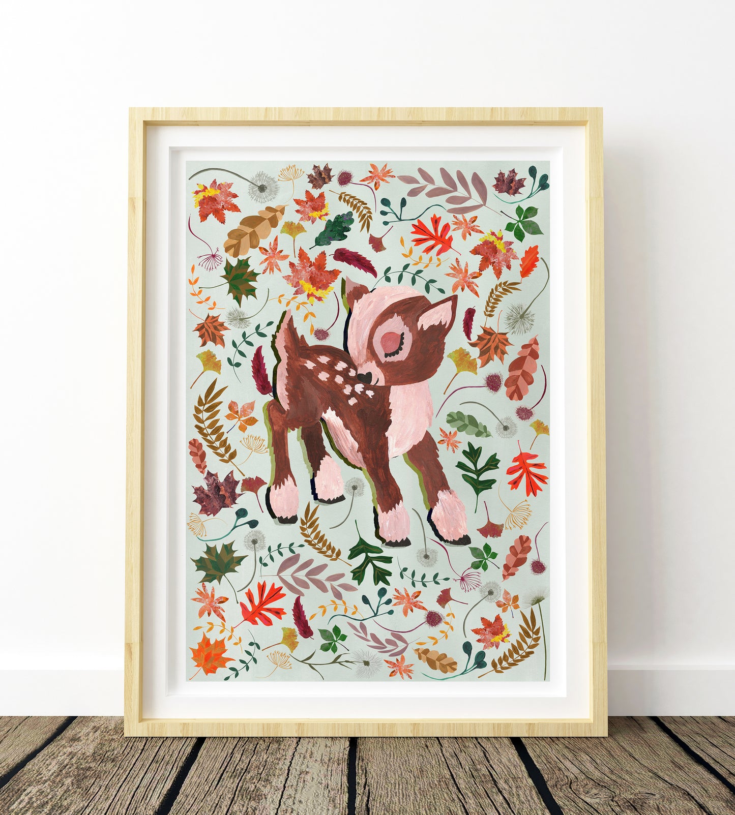 Framed artwork of a deer surrounded by autumn leaves on a white background